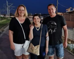 Anja Müller, Stammzellempfängerin Nadja und Anja Müllers Ehemann stehen in Sommerkleidung abends am Strand.