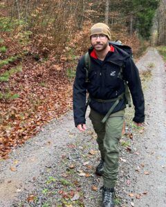 Stammzellspender Philippe geht in Wanderausrüstung durch einen herbstlichen Wald.