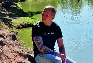 Stammzellspender Andreas sitzt in der Sonne an einem Ufer.