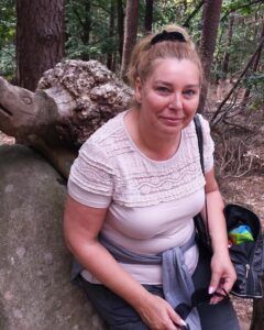 Die 56-jährige Susanne bei einer Wanderpause im Wald.