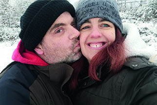 Stammzellspender Chris Albrecht küsst seine Frau in einer Schneelandschaft.